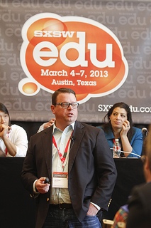 Man speaking in front of Dell-sponsored panel at SXSWedu 2013