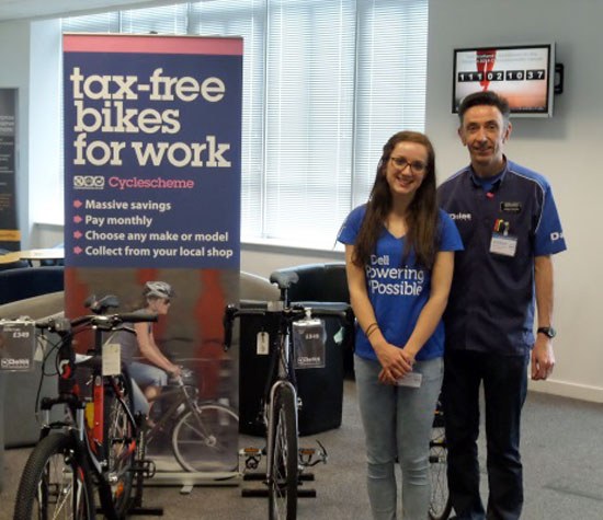 Two people standing by a Dell Bike4Work program sign