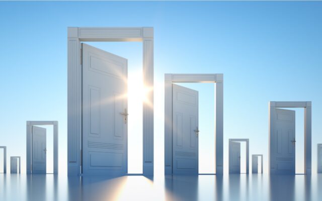 Multiple door frames with open doors scattered across a blue background with sun shining through the closest doorway.