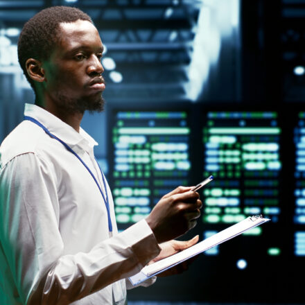 IT programmer using clipboard to assess supercomputer cybersecurity dangers arising due to unsecured network connections. Supervisor making sure high tech facility is invulnerable to malware attacks